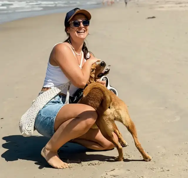Rita Sieber am Strand mit einem Hund